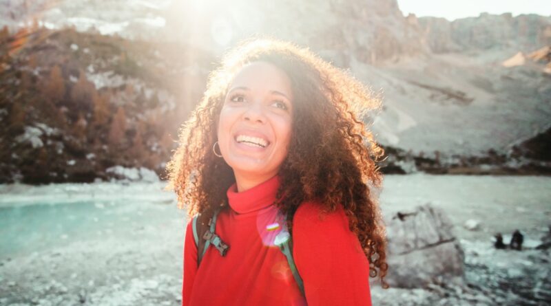 woman wearing red turtle neck shirt near mountain