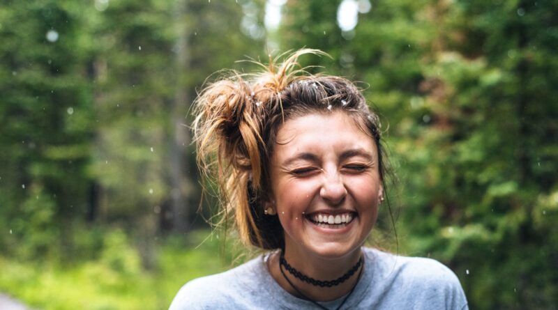 woman smiling near tree outdoor during daytime